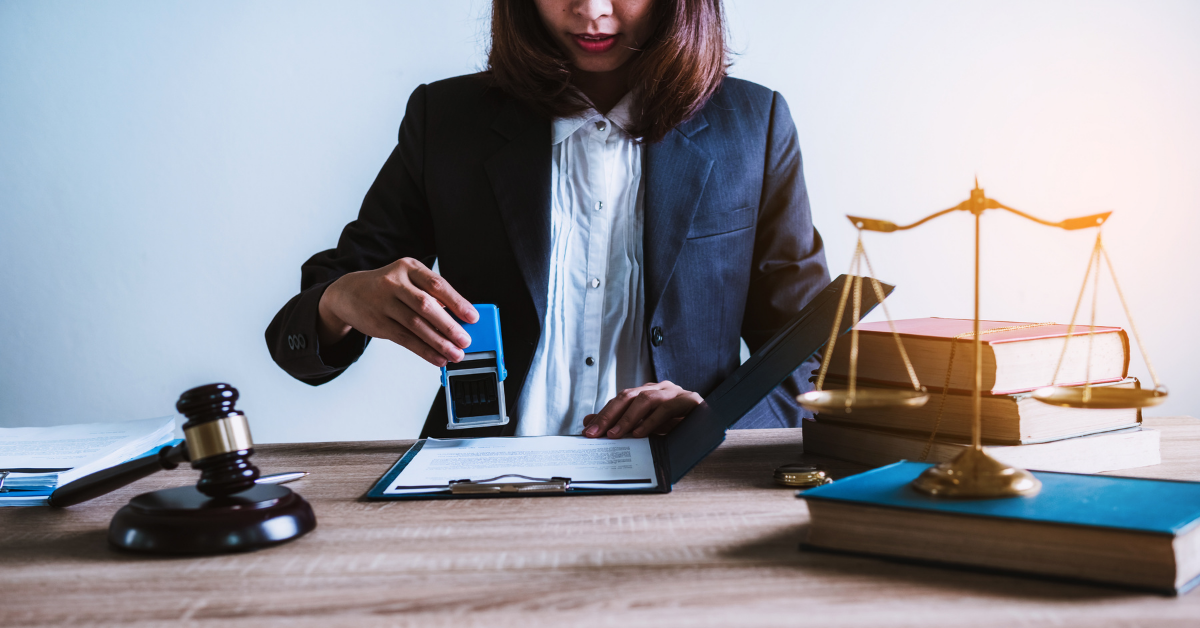 Notary stamping a document at a desk