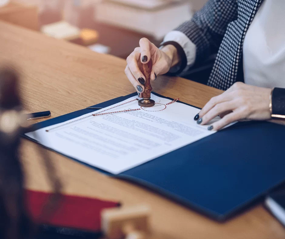 Hands applying a notary stamp to a document