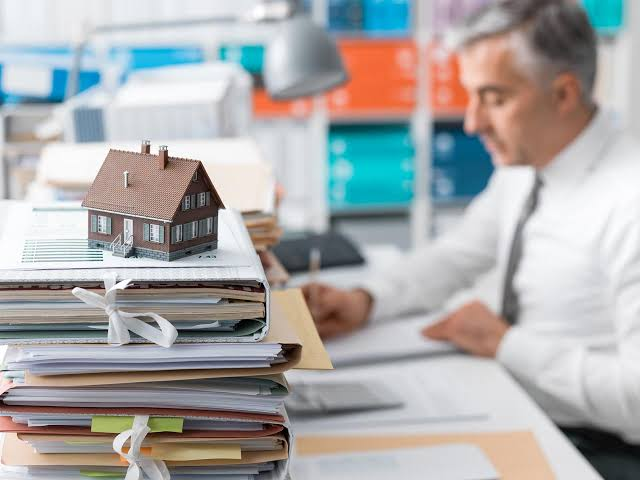 Model house resting on a stack of paperwork