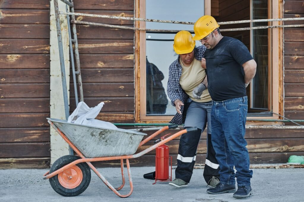 Construction worker supporting an injured colleague at a building site